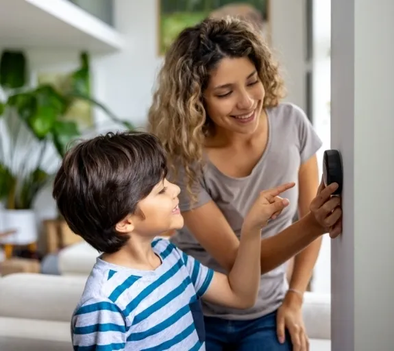 Mother and son adjust home's thermostat