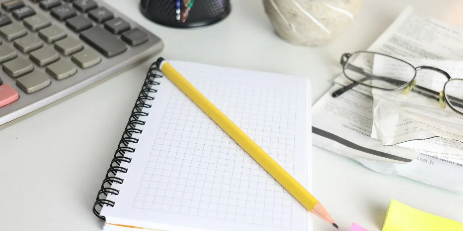 A notepad, pencil and calculator