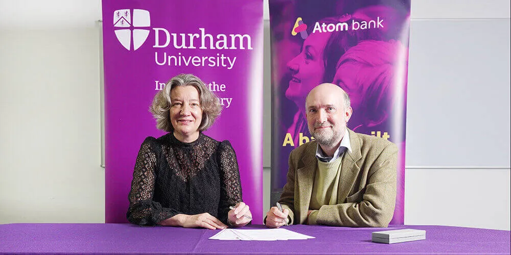 Two people signing an agreement for Durham University