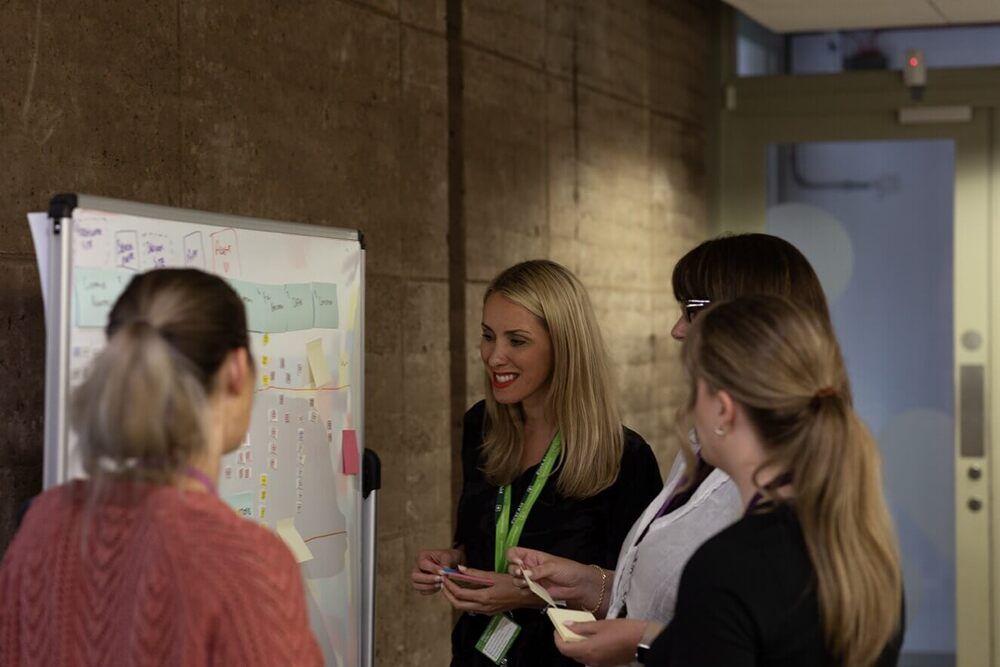 Everyone at Atom bank HQ stood in the lobby looking up and smiling to the camera