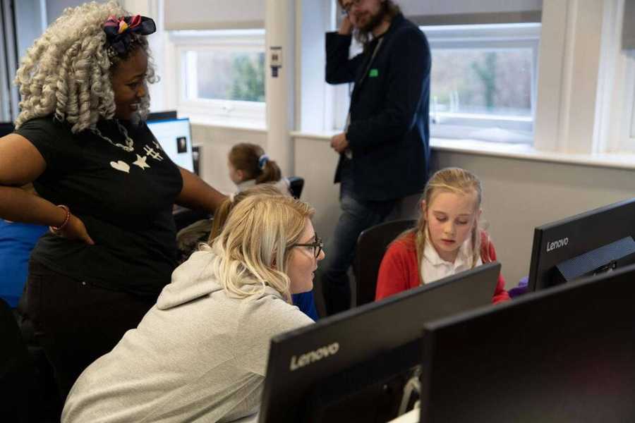 Atom guest from the Stemettes talking to one of the girls at the event about HTML