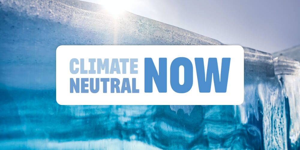 A Climate Neutral Now logo on a background image of an iceberg