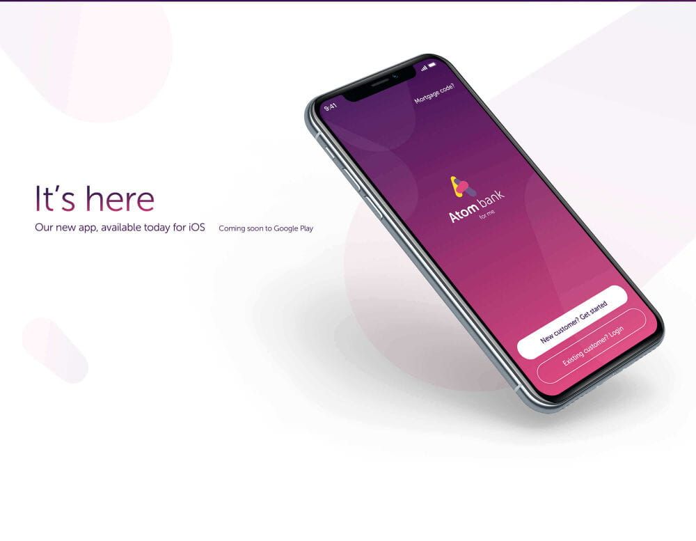 Phone displaying the Atom bank app home page with the words 'It's here, Our new app available today for IOS, coming soon to Google Play'
