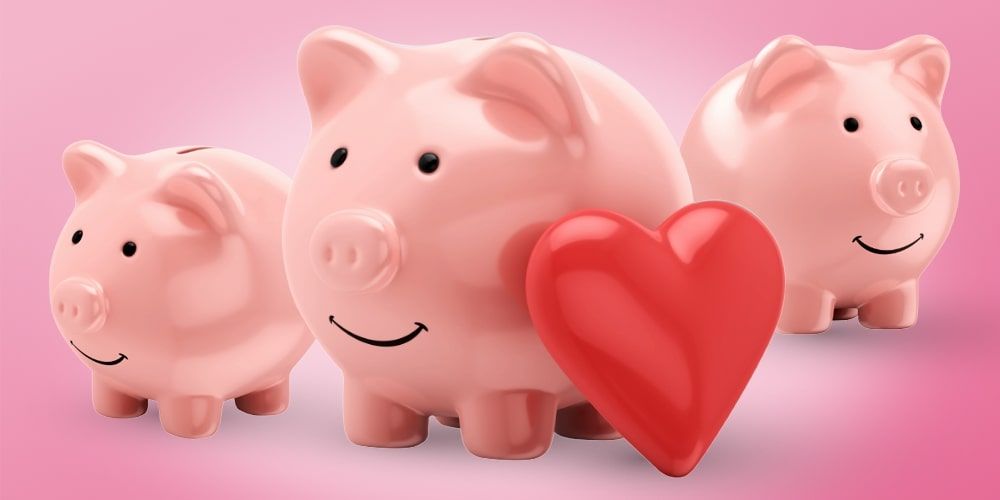 Three porcelain pink piggy banks behind a bright red porcelain heart