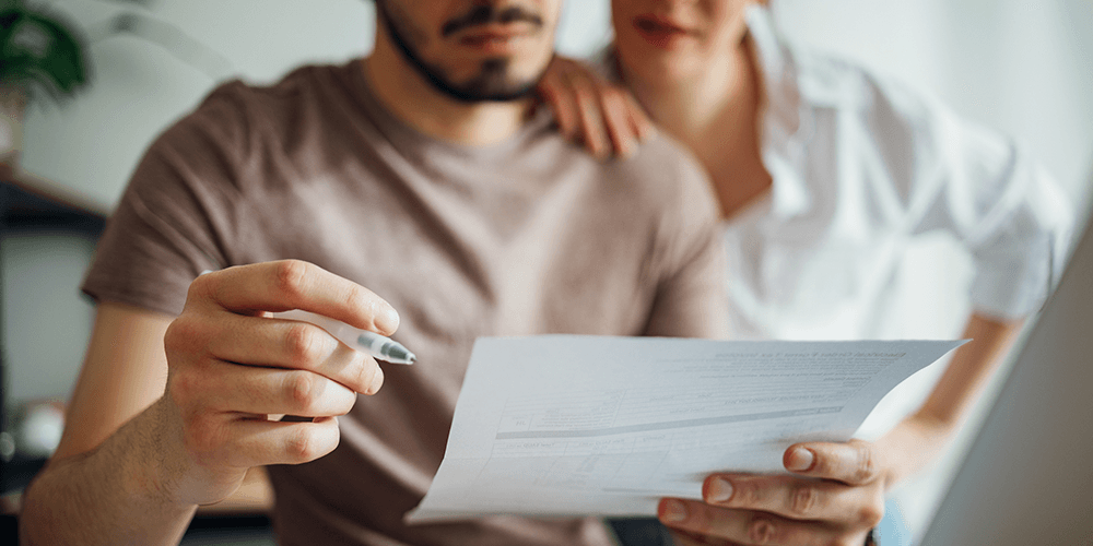 Couple looking at bills waiting for the next cost of living payment