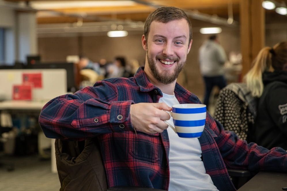 Person smiling with a mug