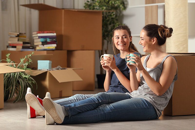 Women sitting on floor in their new home