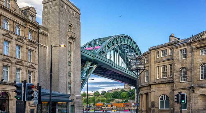 Newcastle Quayside looking up towards the Tyne bridge with a blue sky