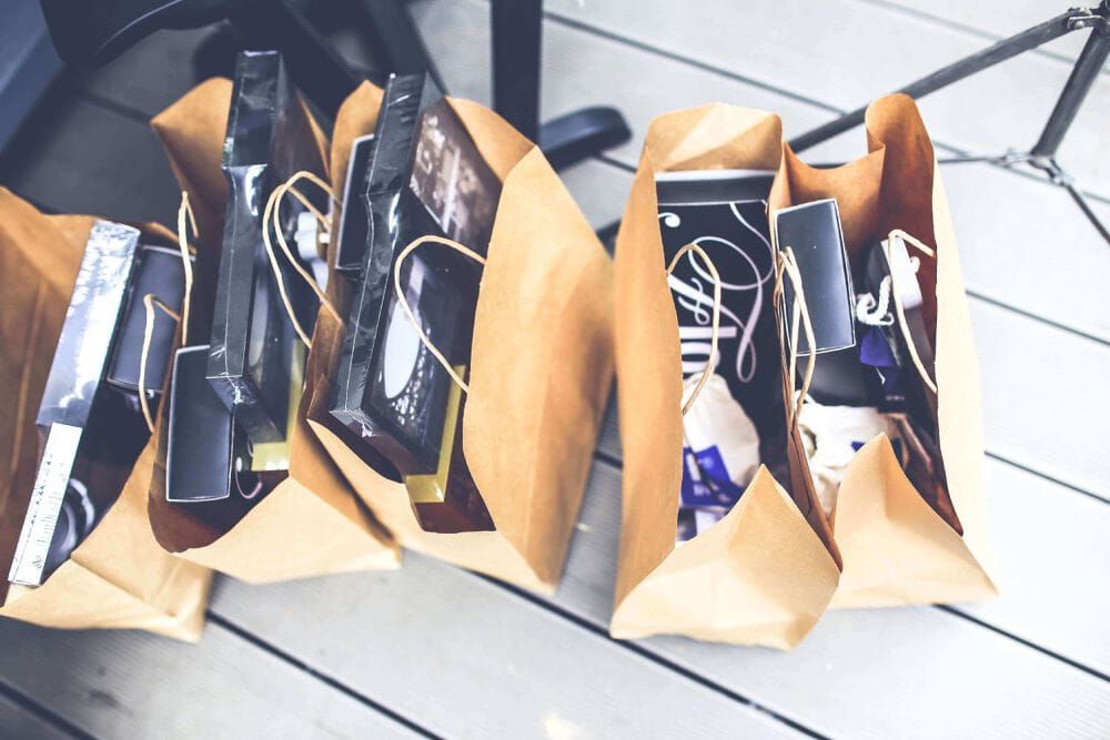 Five brown paper bags sat on the floor, filled with retail shopping