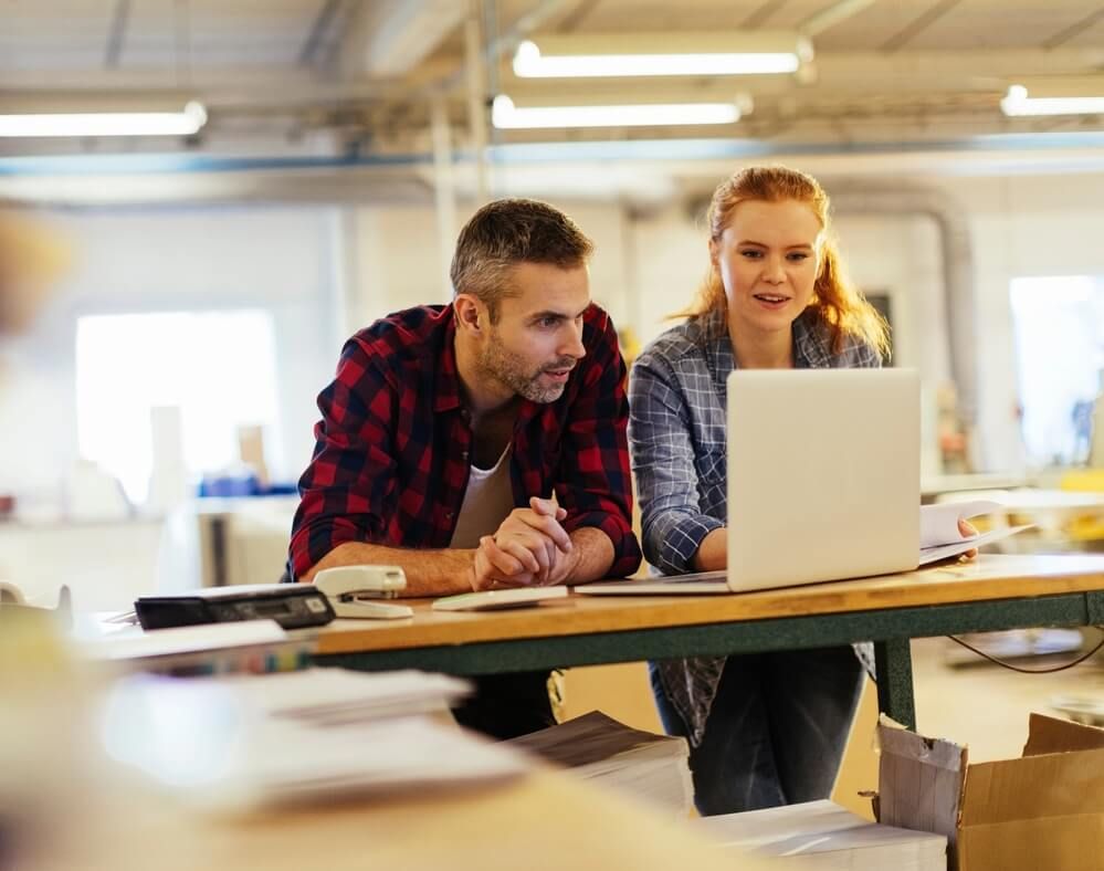 A man and woman looking at a laptop