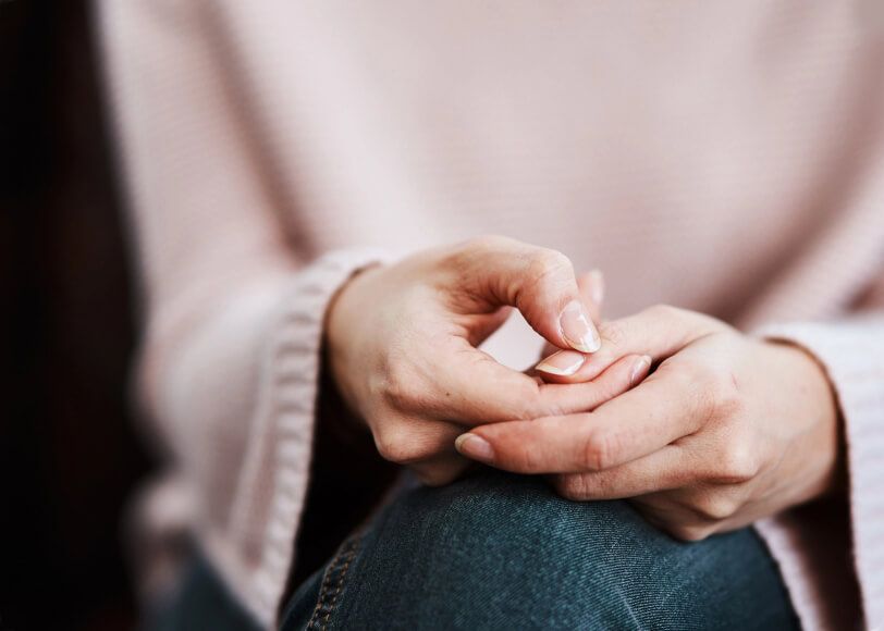 Person moves their fingers together on their knee