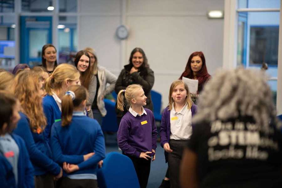 Two girls doing an icebreaker activity at the Atom event