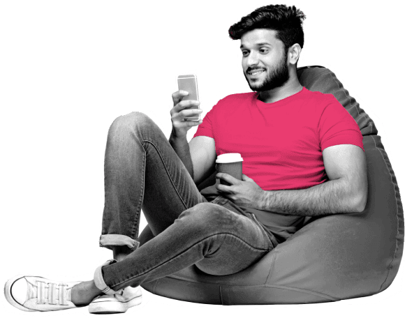 Young man, sat on a bean bag, checking the progress of his Atom mortgage application on his phone