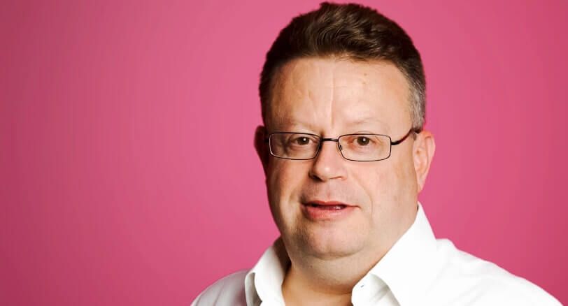 Headshot of Andy Sturrock, Atom's chief technologist, against a pink background