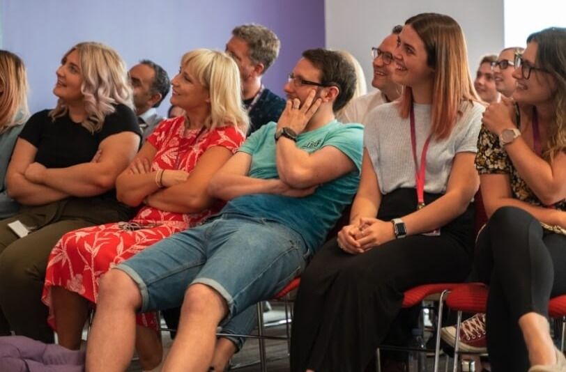 Audience smiling towards an unseen speaker